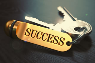 Success key ring with two keys on it